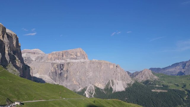 Aerial view of the rugged limestone peaks and green alpine meadows of Sella Pass in Selva, Trentino-Alto Adige, Italy.
