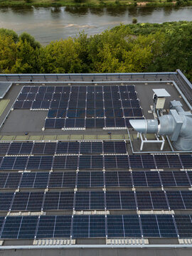 Close-up aerial view of solar panel array mounted in rows on flat commercial rooftop, renewable energy and photovoltaic installation detail concept.