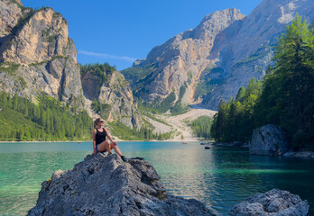 Obraz premium Hiking, excited and woman on mountain with lake for adventure, trekking and freedom. Travel, nature and happy person outdoors for wellness, walking and exercise on holiday, journey and vacation