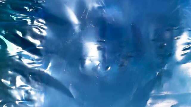 Glossy shiny blue metallic foil texture with abstract folds and reflections