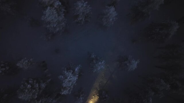 Birds eye aerial view following a fatbike in deep snow of Lapland, winter dusk
