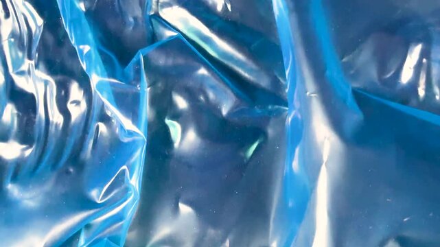 Wrinkled blue plastic wrap texture background close up