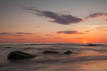 Fototapeta premium Calm sea sunset with rocks and orange sky