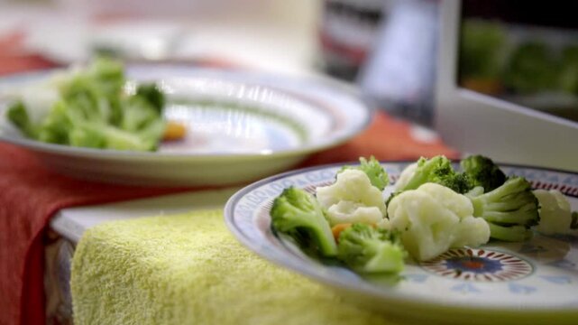 Close up of steamed broccoli and cauliflower florets served on a ceramic plate, highlighting a fresh and nutritious side dish prepared for a healthy meal.
