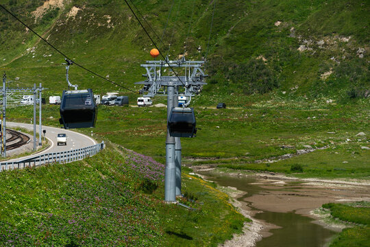 Modular cabins cable car against the bright sky, clouds ans mountains. Cableway - one of the popular urban rides 