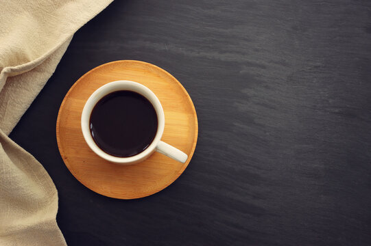 Top view image of coffee cup over black table background.
