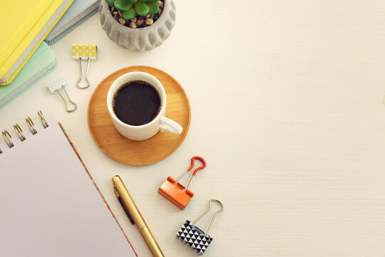 Top view image of table with coffee and office supplies