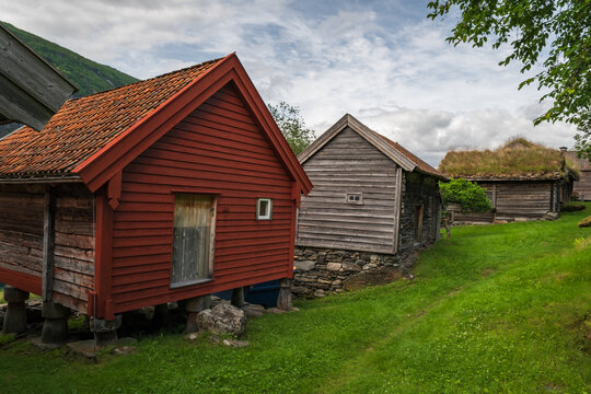 traditional red-painted wooden stabbur storehouse built on stone pillars at the historic Otternes Bygdetun hamlet overlooking Aurlandsfjord, Norway.