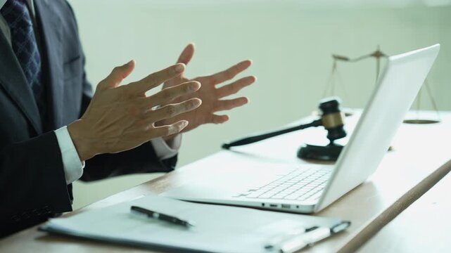 Lawyer working on a laptop with a gavel and scales of justice, representing legal technology, law practice, digital documents, justice, and professional legal services.