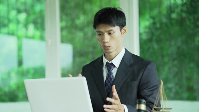 Lawyer presenting a contract while working with a laptop, gavel, and scales of justice, representing legal consultation, business agreements, and professional legal services.