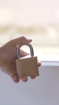 Young child's hand securely locking a heavy-duty metal padlock. Conceptual video representing data protection, privacy, and safety.