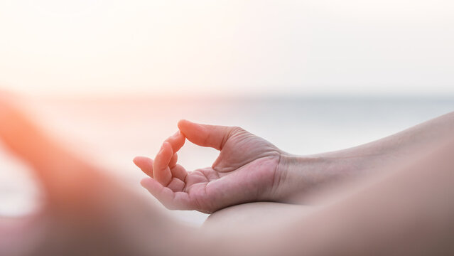Mantra yoga meditation, spiritual mental health practice, human spirit therapy, mental balance concept with yogi person hands in lotus pose relaxing in peace silently on the sea beach