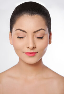 Young woman with eyes closed over white background 