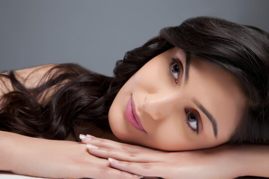 Attractive young female looking away over colored background 
