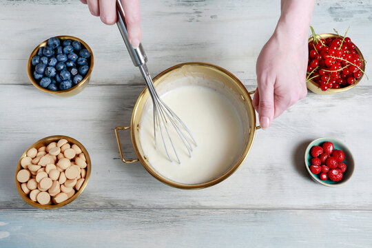 A woman demonstrating a step-by-step tutorial on how to make sweet no-bake desserts using homogenized curd cheese, fresh fruits, and jelly.