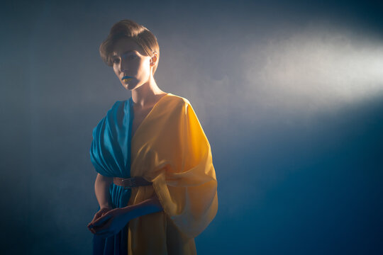 young ukrainian woman in yellow and blue clothes and dress praying for ukraine