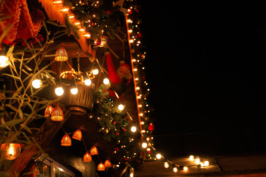 Decorative lights hang on walls during a night Christmas celebration in a festive area