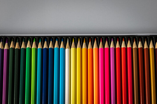 Rainbow Colored Pencils Aligned in Box Below Generous Copy Space