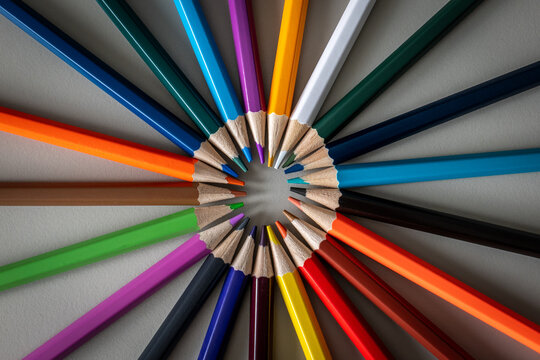 Colored Pencils Form a Vibrant Radial Circle on Gray Background