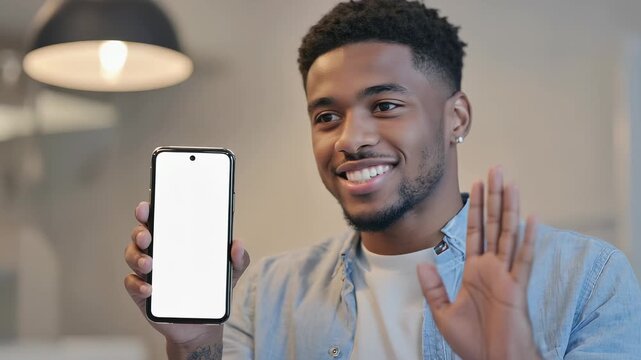 Smiling man presenting smartphone with blank screen, showcasing technology and digital innovation in a modern office environment.