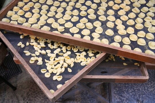 Italian food traditional production - outdoor drying of home-made orecchiette pugliese pasta in Bari, Apulia.