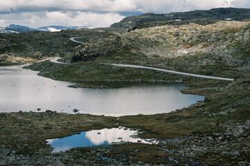 High mountain highway curving along a pristine glacial tarn on the Sognefjellet arctic tundra plateau near Jotunheimen National Park, Norway © Michele