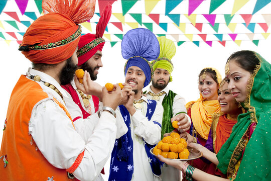 Sikh people eating laddoos 