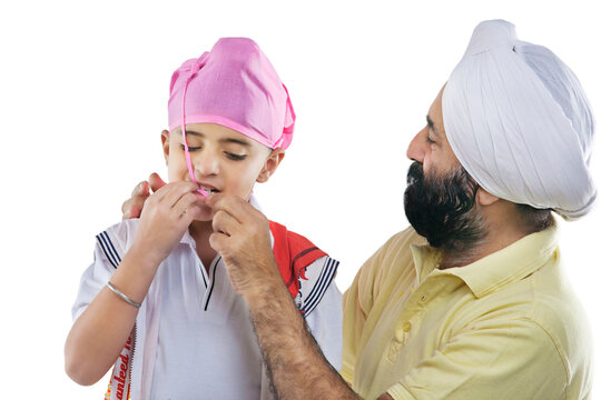 Grandfather helping grandson tie a turban 