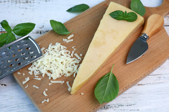 parmesan cheese and basil on wooden board