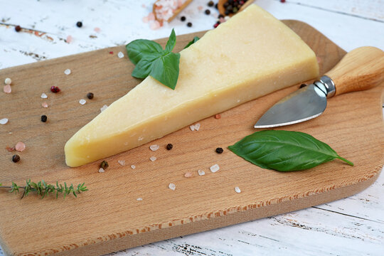 parmesan cheese and basil on wooden board