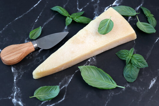 parmesan cheese and basil on black marble