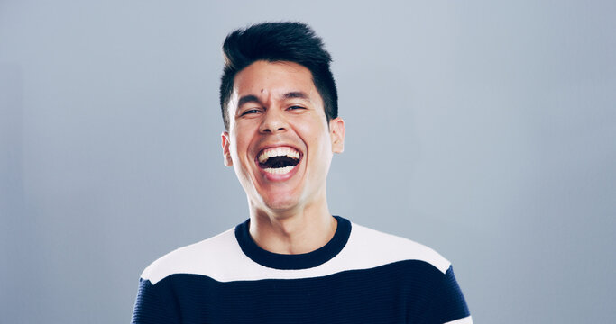 Comic, man and portrait for laugh in studio with confidence, joke or good mood on gray background. Space, excited model and smile with carefree personality for comedy, humor or funny reaction to meme