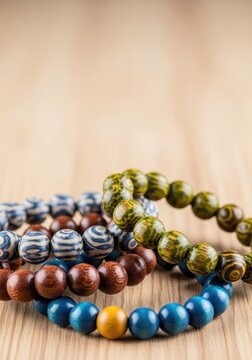A collection of handcrafted wooden bead bracelets resting on a smooth, pale timber surface, showcasing natural textures and organic beauty, beads, organic, style