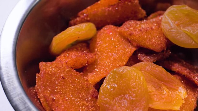 Close up cooking footage showing dried mangos and fried apricots on lazy susan for chamoy during a homemade chamoy sauce recipe prepared from scratch