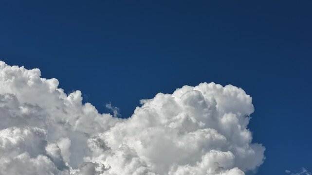 Aerial view of rapidly shifting cumulus clouds against a deep blue sky, capturing dynamic weather patterns over Los Alamos, NM, United States.