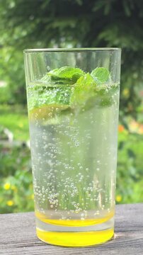 Refreshing drink with mint and bubbles in a garden setting