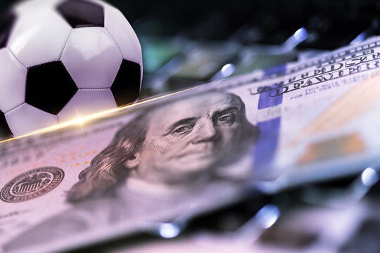 Sport bet on soccer game with money and a soccer ball placed on a table