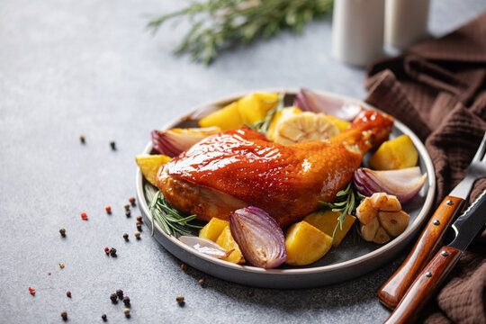 Grilled chicken leg with vegetables on a plate on the table.