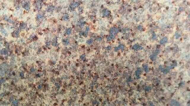 Weathered and worn iron metal sheet surface rust abstract background texture for graphic design use. Old aged dirty rusty material corrosion and weathering damage. Stop motion animation loop.