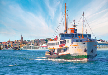 Fototapeta premium Cruise ship and ferry (steamboat) traffic in the Bosphorus - Sea voyage with old ferry (steamboat) on the Bosporus - Coastal cityscape with modern buildings and Galata Tower - Istanbul, Turkey 
