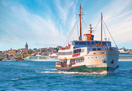 Cruise ship and ferry (steamboat)  traffic in the Bosphorus - Sea voyage with old ferry (steamboat) on the Bosporus - Coastal cityscape with modern buildings and Galata Tower - Istanbul, Turkey  