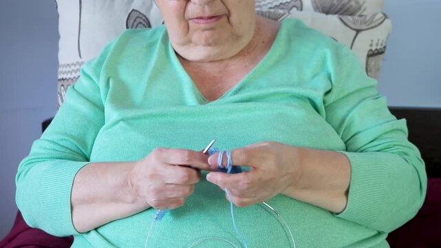 Close-Up of Senior Woman Crocheting Blue Yarn with Skilled Hands
