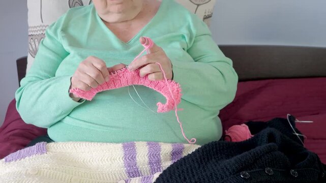Close-Up of Senior Woman Crocheting Pink Yarn with Skilled Hands