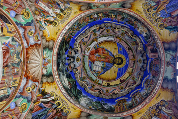 The frescoed dome of the Rila Monastery Church depicts Christ Pantocrator in the center, surrounded by angels, saints, and biblical scenes. © Nick