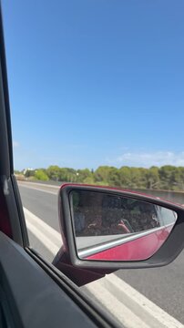 Road trip driving with side mirror reflection on a sunny day