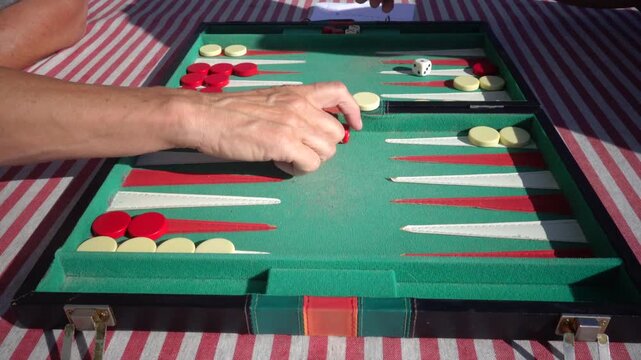 Hirtshals, Denmark Two people playing backgammon while rolling dice. 