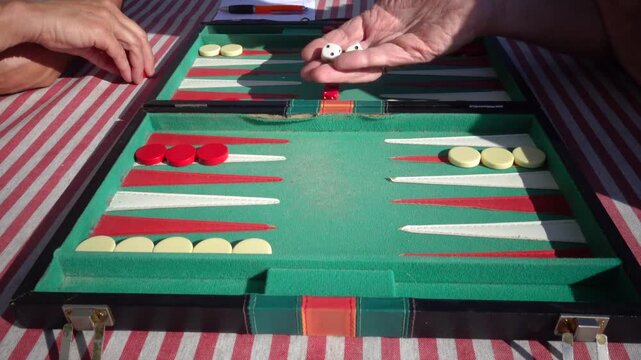 Hirtshals, Denmark Two people playing backgammon while rolling dice. 