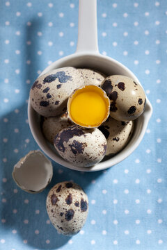 Saucepan of whole and opened quail eggs on cloth