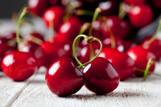 Stems of two cherries building a heart
