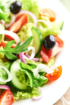 Salad with Olives, Tomatoes and Cucumber on wooden Background. Healthy Snack Idea. Close up